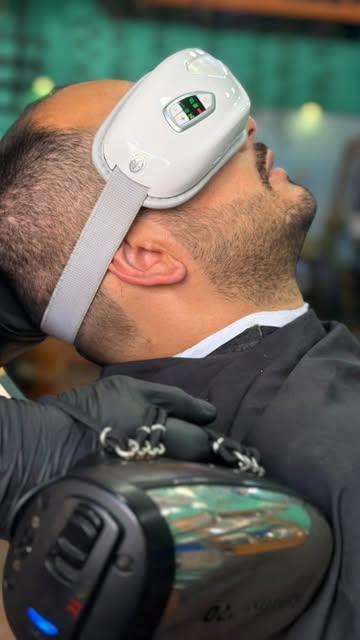 Cliente con gafas masajeadoras durante un combo de barbería